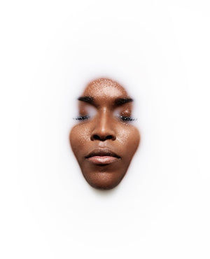 Model  in milk bath with eyes closed